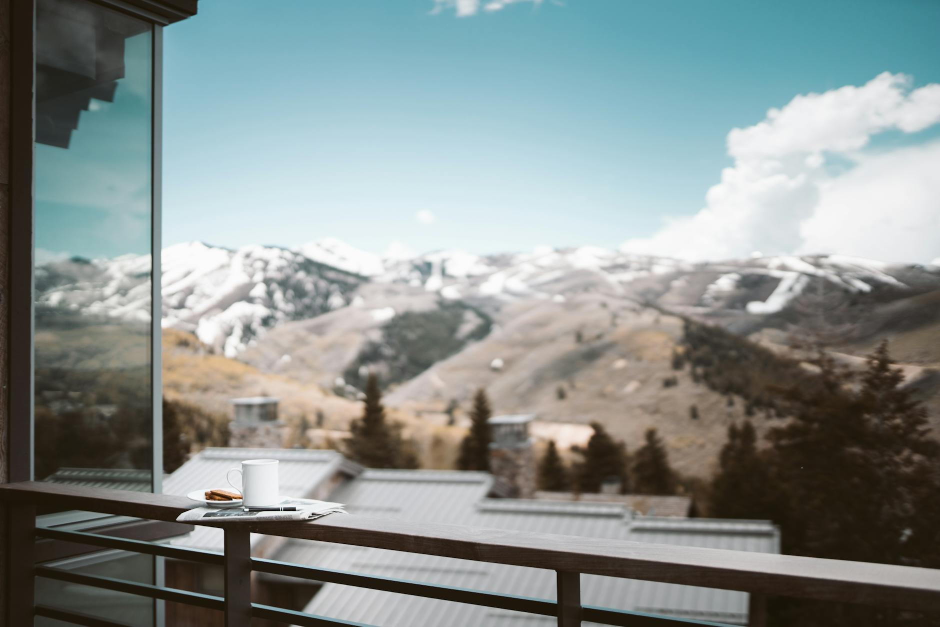 Poranna kawa na drewnianym balkonie z widokiem na ośnieżone góry