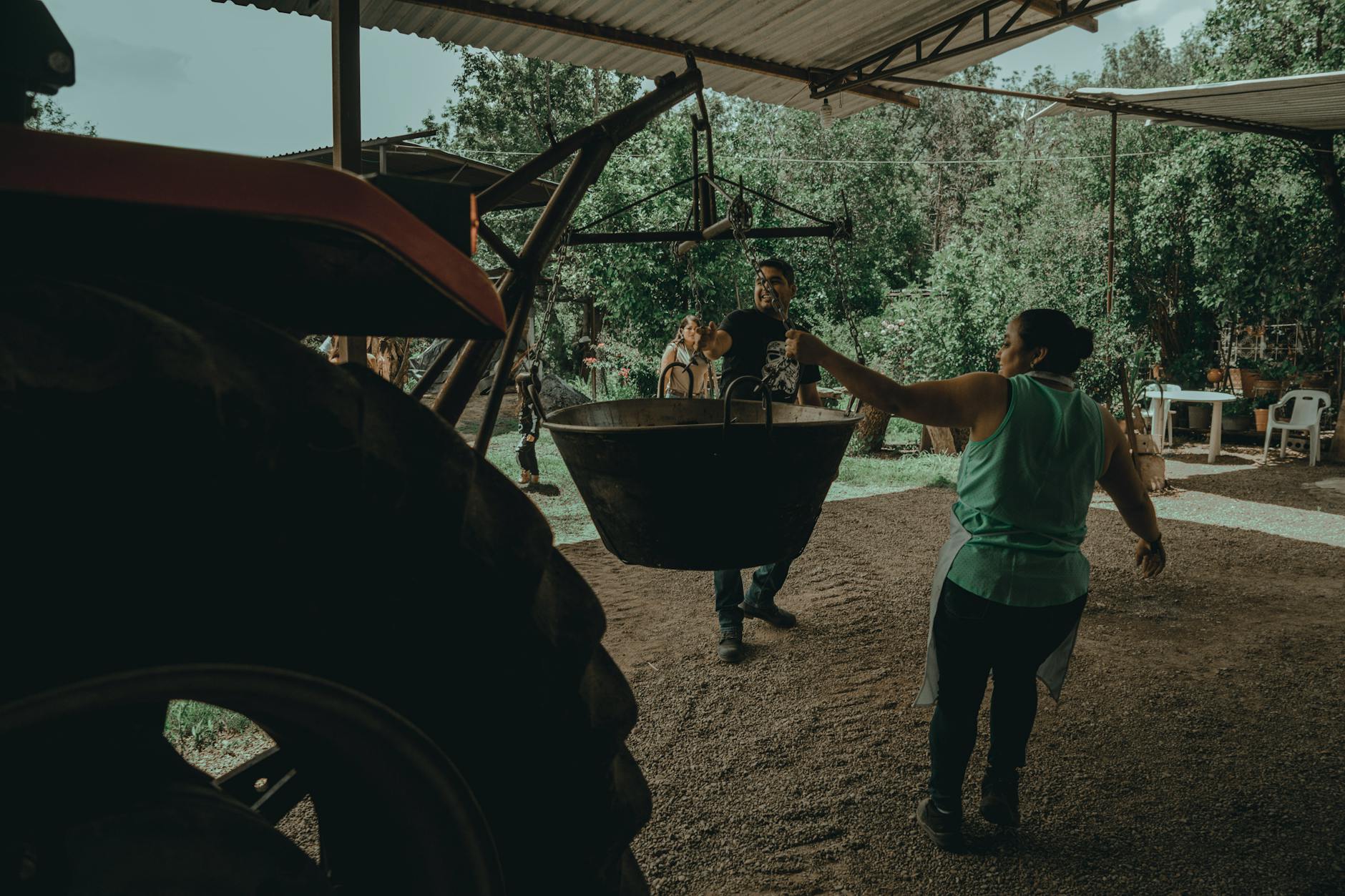 Rodzina z dziećmi pomaga przy pracach w gospodarstwie obok traktora