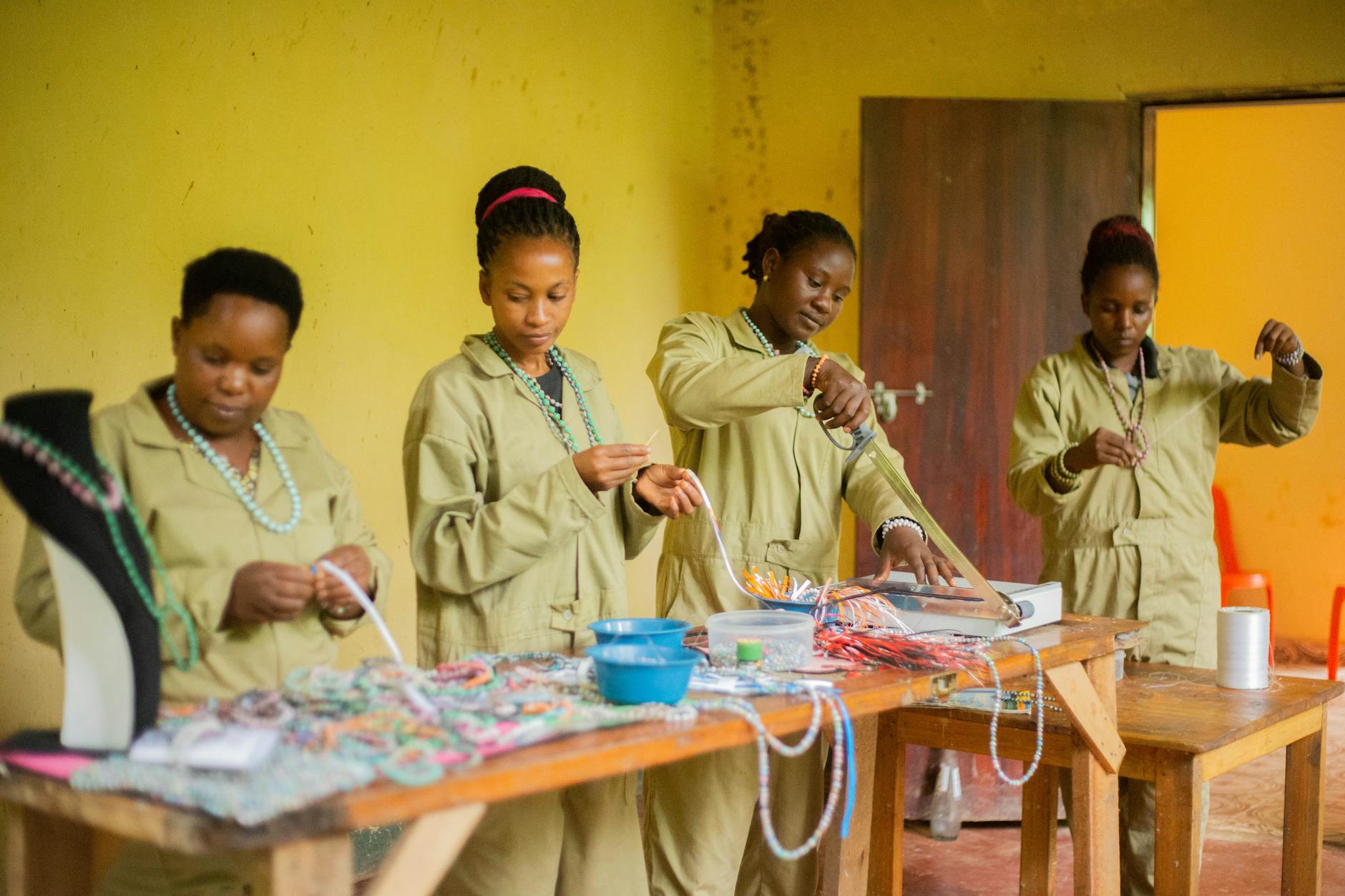 Kobiety w pracowni agroturystycznej tworzą kolorową biżuterię z koralików