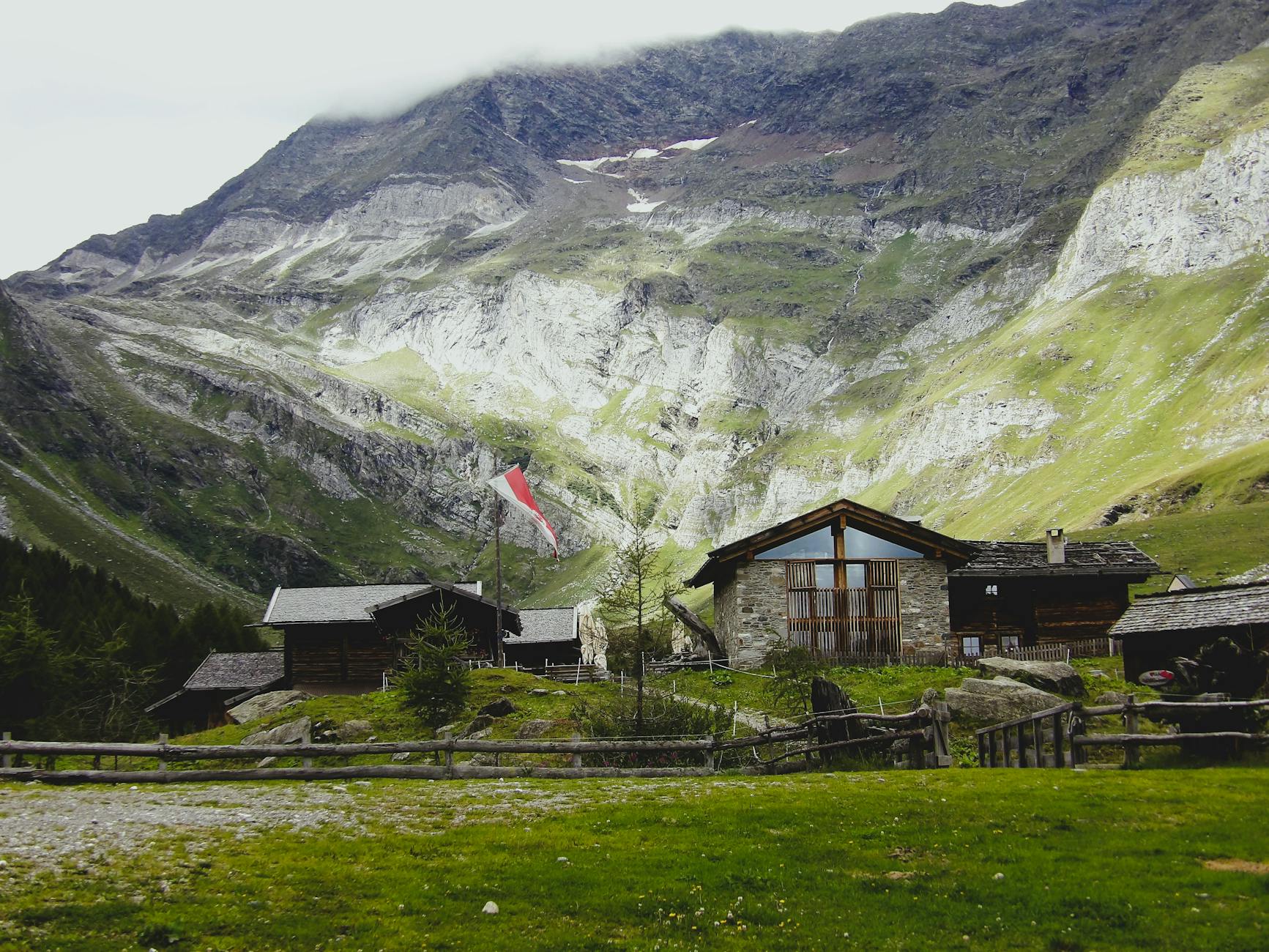 Górska agroturystyka z tradycyjnym domem na tle szczytów Trentino