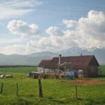 Sielskie gospodarstwo agroturystyczne na tle gór pod bezchmurnym niebem